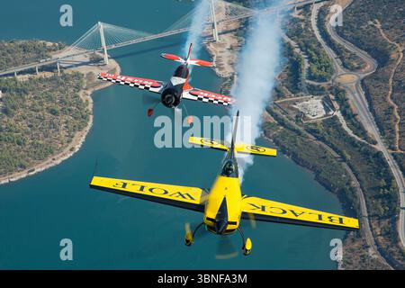 Le Black Wolf Extra EA-330SC (Reg. F-HMKF) et le Dutch Rush Aerobatics Sukhoi Su-26MX présentent leurs prouesses acrobatiques sur la Grèce. L'Extra EA-330SC est un avion de voltige de haute performance connu pour son agilité et son contrôle précis, tandis que le Sukhoi Su-26MX est un avion de voltige de compétition, connu pour sa puissance et sa maniabilité. Les deux avions sont présentés dans un affichage impressionnant de précision aérienne. Banque D'Images