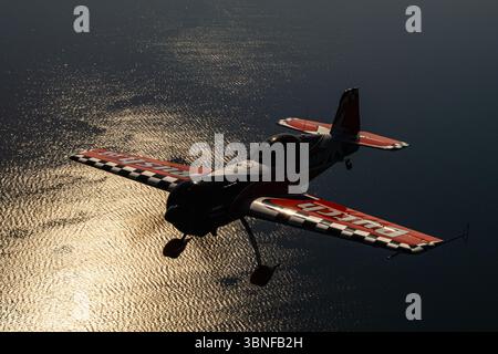 Le Dutch Rush Aerobatics Sukhoi Su-26MX est capturé en silhouette alors qu'il effectue des manœuvres acrobatiques spectaculaires au-dessus de la Grèce. Le Su-26MX, connu pour son agilité incroyable et sa puissance brute, se démarque dans les événements acrobatiques, démontrant souvent les limites du contrôle de vol avec son large éventail de compétences acrobatiques. Banque D'Images