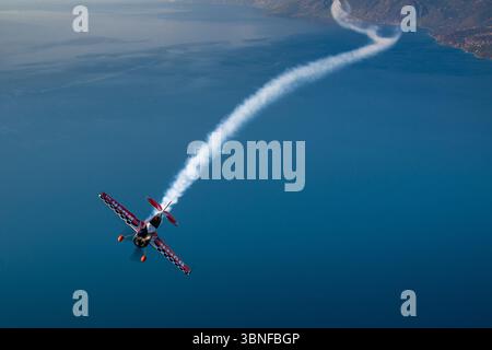 Le Dutch Rush Aerobatics Sukhoi Su-26MX effectue une manœuvre acrobatique au-dessus de la Grèce, laissant une épaisse traînée de fumée. L'avion est très apprécié pour sa vitesse, son agilité et sa précision dans l'exécution de routines acrobatiques complexes, démontrant les capacités du Su-26MX construit en Russie. Banque D'Images