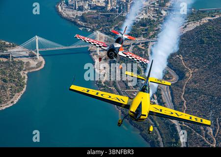 Lors d'une performance acrobatique au-dessus de la Grèce, le Black Wolf Extra EA-330SC (Reg. F-HMKF) et le Dutch Rush Aerobatics Sukhoi Su-26MX créent un affichage impressionnant, libérant des traînées de fumée alors qu'ils exécutent des manœuvres avancées. Les deux avions sont réputés pour leur agilité, avec l'Extra EA-330SC connu pour son extrême précision et le Sukhoi Su-26MX pour ses puissantes capacités acrobatiques. Banque D'Images