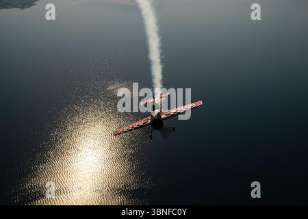 Le Dutch Rush Aerobatics Sukhoi Su-26MX libère un panache de fumée alors qu'il complète une manœuvre acrobatique audacieuse au-dessus de la Grèce. Connu pour sa grande agilité et son moteur puissant, le Su-26MX est un excellent exemple d'avion acrobatique de haut niveau, exécutant des manœuvres nettes et précises dans le ciel. Banque D'Images