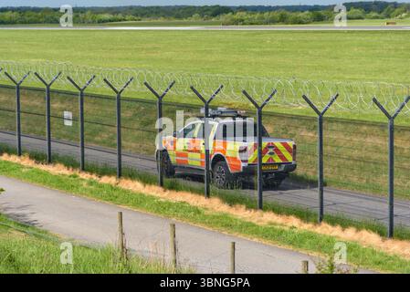 Garde de l'aéroport sur une voie de service près de la piste Banque D'Images