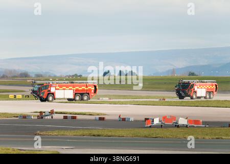 Les pompiers traversent la piste à l'aéroport de Manchester Banque D'Images