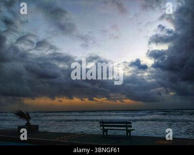 Crépuscule orageux sur la mer – vagues sauvages et banc solitaire en Crète, Grèce Banque D'Images