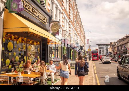 WIMBLEDON, LONDRES- 2 juillet 2025 : décorations de tennis et personnes dans la rue principale de Wimbledon Village pendant les championnats de Wimbledon 2025. Banque D'Images
