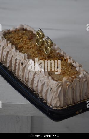 Un gâteau d'anniversaire avec des bougies de couleur dorée en forme de numéro 88. Banque D'Images