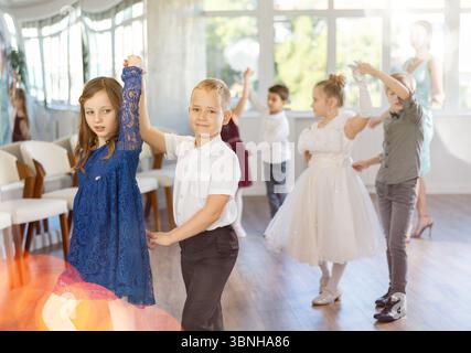 Tween filles ad garçons dansant la danse partenaire lente pendant l'événement festif Banque D'Images