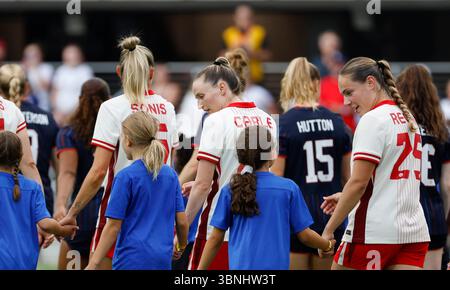 Washington DC, États-Unis. 2 juillet 2025. Milieu de terrain de l'équipe nationale féminine du Canada (25) Emma Regan et défenseuse de l'équipe nationale féminine du Canada (21) Gabrielle Carle discutent avec les jeunes filles de soccer qui les ont escortées sur le terrain avant un match de soccer amical international dans l'Allstate Continental Clasico entre l'équipe nationale féminine des États-Unis et l'équipe nationale féminine du Canada à Audi Field à Washington DC Justin Cooper/CSM/Alamy Live News Banque D'Images