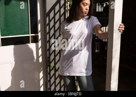 Illustration plate montrant une femme debout dans la porte jetant des ombres en treillis sur la porte et la vigne Banque D'Images