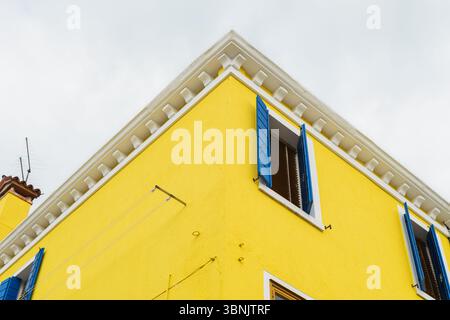L'image montre un bâtiment jaune vif avec des volets bleus frappants à Murano & Burano, Venise, illustrant l'architecture colorée typique de O. Banque D'Images