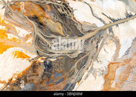 Vue aérienne d'un paysage coloré et dynamique présentant des motifs et des textures de terre complexes. L'image capture la beauté abstraite de la topographie et Banque D'Images