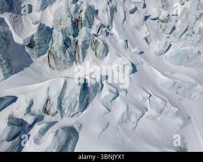 Une vue aérienne à couper le souffle d'un glacier dans les Alpes suisses, mettant en évidence des motifs complexes et des formations glacées, capturant la beauté majestueuse et fragi Banque D'Images