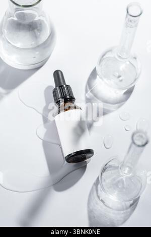 D'en haut flatlay minimaliste de compositions cosmétiques artistiques sur fond blanc, présentant une variété de solutions de soins de la peau dans un récipient élégant Banque D'Images
