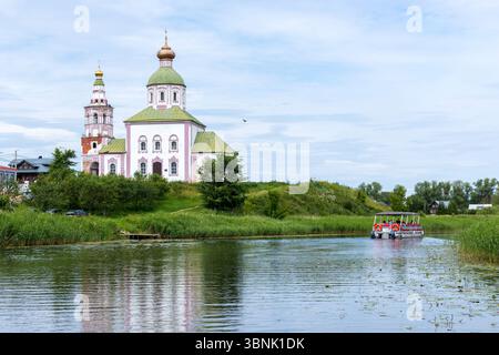 Beau paysage d'été à Souzdal. Église d'Élie le Prophète (église Élie) sur la rive de la rivière Kamenka. Les touristes sur le bateau de tramway fluvial flottent sur rive Banque D'Images