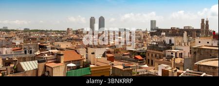 Vue panoramique sur les toits de la vieille ville de Barcelone, avec les tours jumelles de Port Olímpic et la basilique Santa Maria del Mar au loin. Banque D'Images