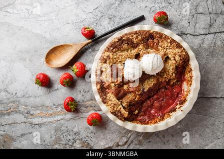 Cordonnier de fraise au cacao fait maison avec crème glacée à la vanille gros plan dans un plat de cuisson sur la table. vue horizontale de dessus Banque D'Images