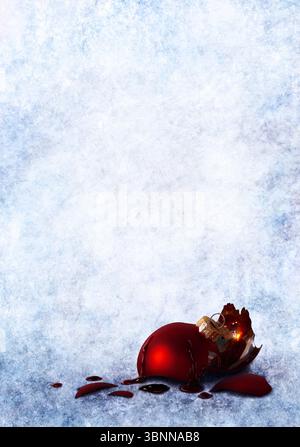 Une boule de sapin de Noël cassée avec des traces de sang au milieu d'une étendue de neige glacée Banque D'Images