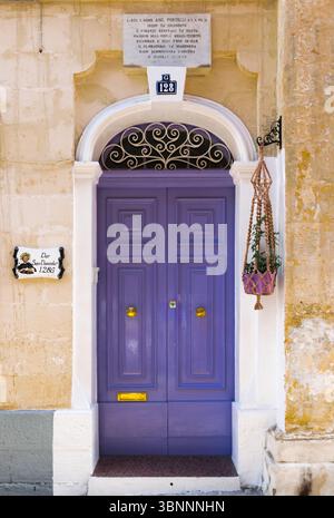 La Valette, Malte : 9 février 2024 : porte violette double voûtée traditionnelle à la Valette avec plaque commémorative Banque D'Images
