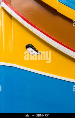 Marsaxlokk, Malte - 9 février 2024 : gros plan d'un Luzzu coloré, bateau de pêche traditionnel avec l'œil d'Horus dans le port de Marsaxlokk Banque D'Images
