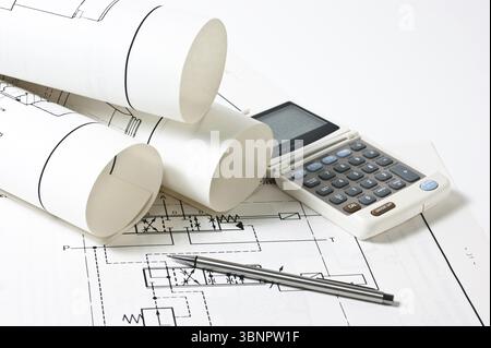 Dessins techniques roulés et une calculatrice Banque D'Images