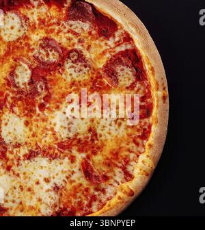 Nature morte, Pizza au salami, fromage parmesan sur noir Banque D'Images