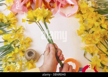 Homme fleuriste fait des bouquets de fleurs jonquilles Banque D'Images