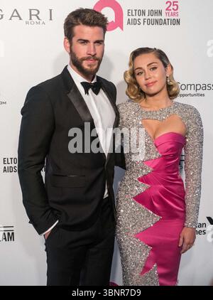 (FILE) Miley Cyrus recevra une étoile sur le Hollywood Walk of Fame en 2026. Miley Cyrus fait partie des 35 lauréats annoncés le mercredi 2 juillet 2025 par Eugenio Derbez et Richard Blade. WEST HOLLYWOOD, LOS ANGELES, CALIFORNIE, États-Unis - MARS 04 : L'acteur australien Liam Hemsworth portant un tux Burberry et sa petite amie/chanteuse américaine, auteur-compositeur et actrice Miley Cyrus portant une double robe rose et scintillante Moschino arrive à la 26e soirée annuelle des Oscars de la Fondation Elton John AIDS qui s'est tenue au City of West Hollywood Park le 4 mars 2018 à West Hollywood, Los Angeles, Californie, Unit Banque D'Images