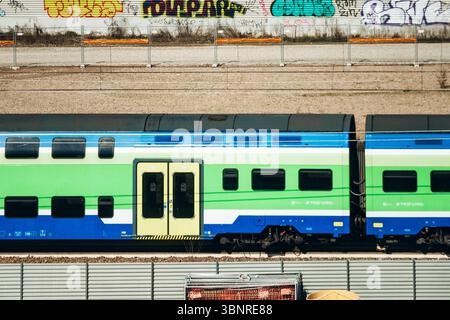 Milan, Italie - 19 mars 2025 : le train Trenord passe devant le chantier de construction du village olympique près de la Fondazione Prada Banque D'Images