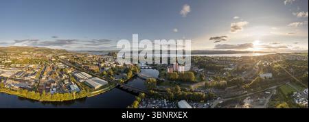Vue aérienne de la rivière Leven coulant à travers la ville vers Dumbarton Rock sous un coucher de soleil radieux, Dumbarton, Écosse, Royaume-Uni. Banque D'Images