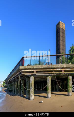 Royaume-Uni, Londres, 09 juillet 2025. Vue sous une passerelle le long de la Tamise à marée basse, avec des piliers couverts de mousse et des ombres projetées sur l'australie méridionale Banque D'Images