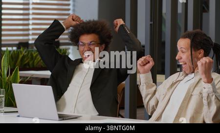 Deux hommes afro-américains gars multiraciaux hommes d'affaires multiethniques collègues collègues collègues regardant ordinateur portable dans le travail de bureau Banque D'Images