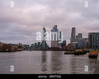 Londres, Royaume-Uni, 16 décembre 2024. Skyline résidentielle et commerciale moderne de neuf ormes avec des reflets sur la Tamise sous un ciel nuageux Banque D'Images
