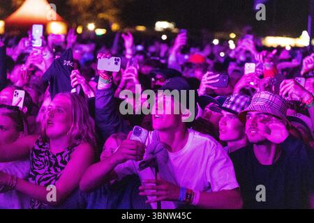 Roskilde, Danemark. 04 juillet 2025. Des festivaliers vus lors du concert du rappeur et chanteur anonyme danois D1MA portant un masque sur la scène Orange au Roskilde Festival 2025. Le festival est le plus grand de son genre dans les pays nordiques avec un total de 130 000 participants attendus pendant les 7 jours du festival. La zone de camping a ouvert quatre jours avant le festival. Olivia Rodrigo, Charli XCX, Fontaines D.C. et MØ sont les vedettes. Crédit : SOPA images Limited/Alamy Live News Banque D'Images