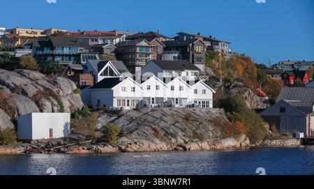 Beau village côtier avec des maisons modernes et traditionnelles sur des falaises rocheuses au bord de l'eau. Le cadre serein met en valeur l'harmonie de la nature et Banque D'Images
