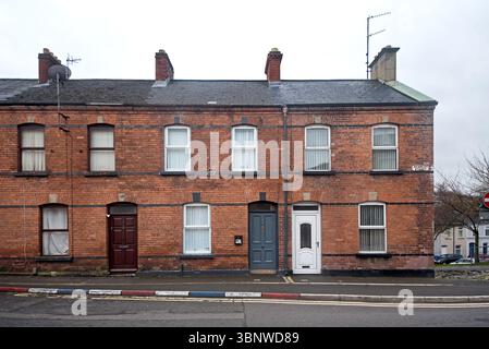 Maisons mitoyennes en briques rouges dans la zone de la fontaine loyaliste de Londonderry, Irlande du Nord. Banque D'Images