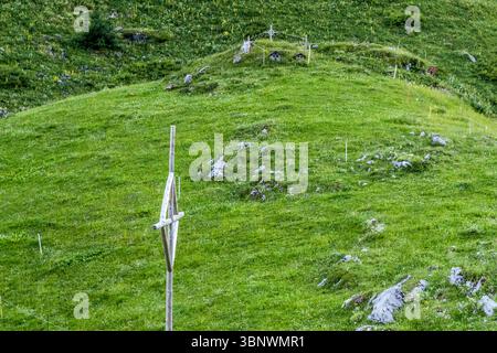 Un monument alpin avec une croix et de petits sanctuaires se dresse sur un pâturage de montagne vert à Hobiel, Uri, Suisse. Ce site est un lieu de contemplation au milieu des Alpes suisses Banque D'Images