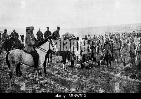 Le général Sarrail félicite les troupes de première ligne pendant la première Guerre mondiale cette image de L'illustration montre un général monté s'adressant à des soldats rassemblés sur le terrain, probablement sur le front des Balkans vers 1916. Le moment capture une visite qui redonne le moral au milieu des difficultés de la guerre des tranchées. Sarrail commande les forces alliées dans la campagne de Salonique, un front moins connu mais stratégiquement important. Banque D'Images