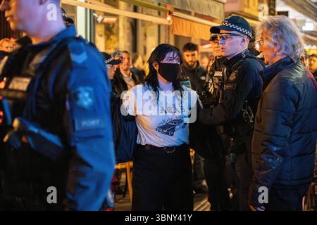 Melbourne, Australie. 04 juillet 2025. Un manifestant est arrêté par des policiers. Un restaurant de Melbourne, « Miznon », lié à un groupe humanitaire israélien, devient une scène de crime alors que les manifestants renversent des tables, brisent des assiettes, des bouteilles et du verre. de nombreux manifestants ont été arrêtés. Crédit : SOPA images Limited/Alamy Live News Banque D'Images