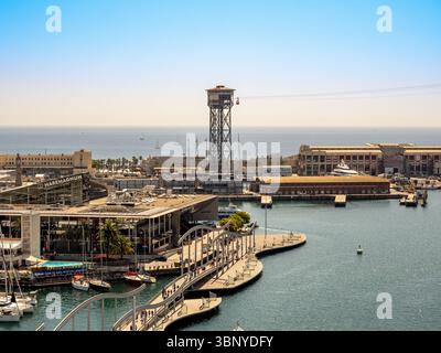 Vue panoramique de Port Vell, Barcelone, Espagne, avec le pont de la Rambla de Mar, le centre de Maremagnum et la tour du tramway aérien de Port Vell. Banque D'Images