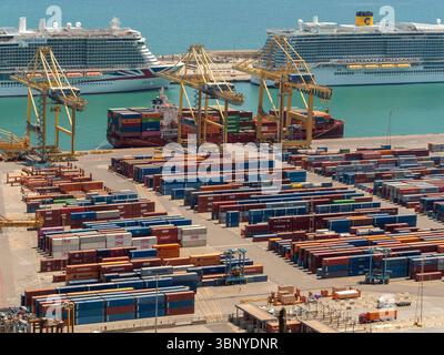 Un porte-conteneurs est chargé par des portiques au port de Barcelone, avec de grands paquebots de croisière amarrés en arrière-plan, Espagne. Banque D'Images