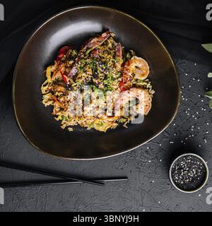 Nature morte, vue de dessus de riz frit avec fruits de mer et légumes préparés dans un wok chinois Banque D'Images