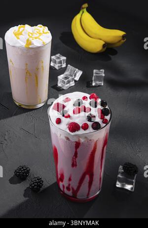 Délicieux milkshakes sur pierre noire avec des glaçons Banque D'Images
