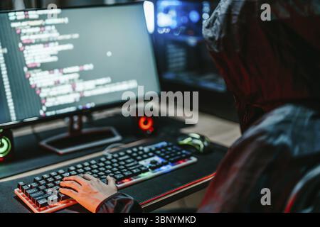 Hooded Hacker codage détruire le système de données en ligne avec le virus ransomware dans le serveur Banque D'Images