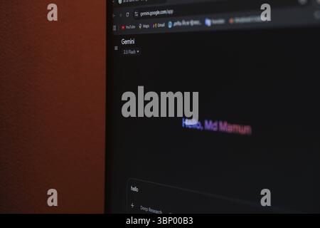 Écran montrant une interface Gemini ai avec un message d'accueil textuel coloré en mode sombre près d'un mur rouge Banque D'Images