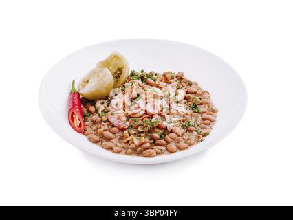 Food Still-Life, Une assiette présente des haricots Pinto assaisonnés vibrants mélangés à des herbes fraîches, accompagnés de tranches de piments et de légumes marinés, Banque D'Images