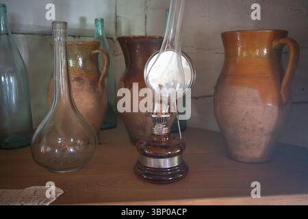 Une table avec une lampe et quelques vases. Les vases sont de différentes tailles et couleurs Banque D'Images