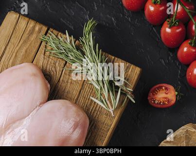 Nature morte, filets de poulet crus sur planche à découper en bois, vue de dessus Banque D'Images