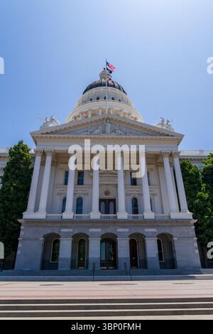 Sacramento, Californie, États-Unis - 21 juin 2025 : bâtiment historique du Capitole de Californie, vue de face, avec drapeaux californien et américain Banque D'Images