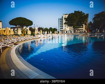piscine ensoleillée avec chaises longues et parasols – 15 juin 2025 Banque D'Images