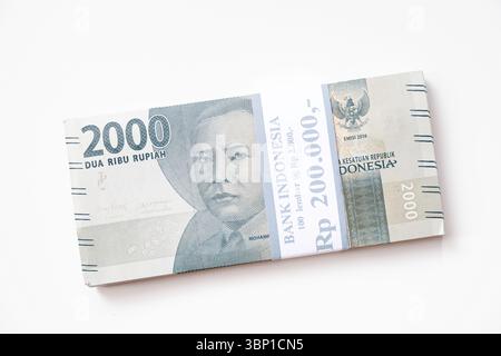 Pekanbaru, Indonésie - 21 mars 2025 : une pile de billets de banque rupiah indonésiens RP 2,000 isolés sur fond blanc pour THR sur Eid al-Fitr ou Lebaran Banque D'Images